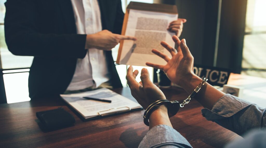 The police officer pointed to the document requesting the arrest